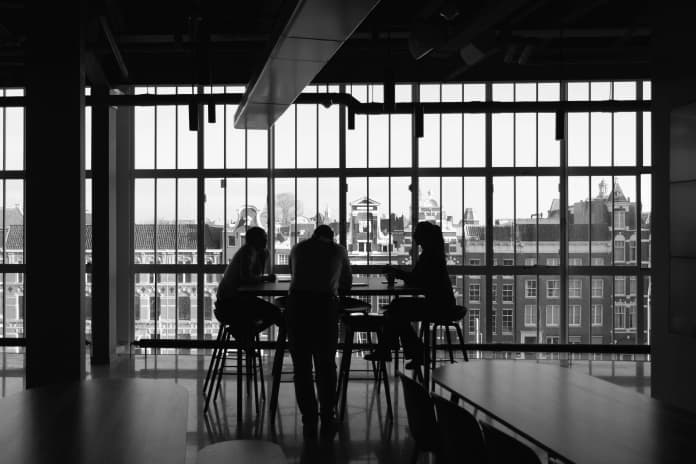 a group of people sitting at a table in front of a window